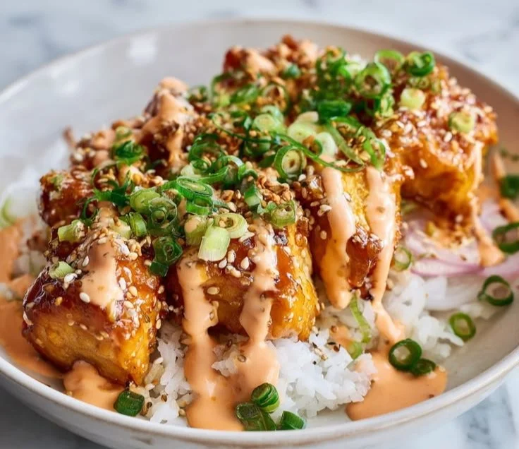 A delicious Bang Bang Chicken Bowl with crispy chicken, colorful vegetables, and spicy sauce.