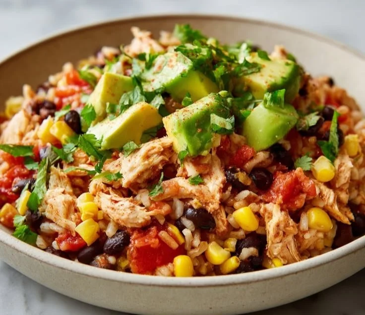 Healthy southwest chicken bowl topped with fresh vegetables and spices.