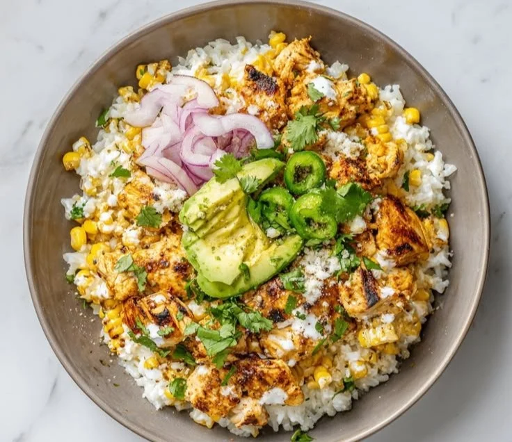 Delicious Mexican street corn chicken bowls garnished with lime and cilantro