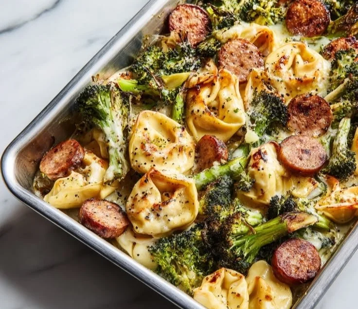 Sheet pan broccoli tortellini bake with melted cheese and fresh vegetables