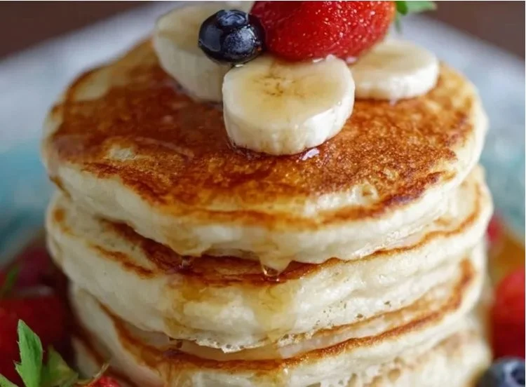 Delicious Greek yogurt pancakes stacked on a plate with fresh berries.