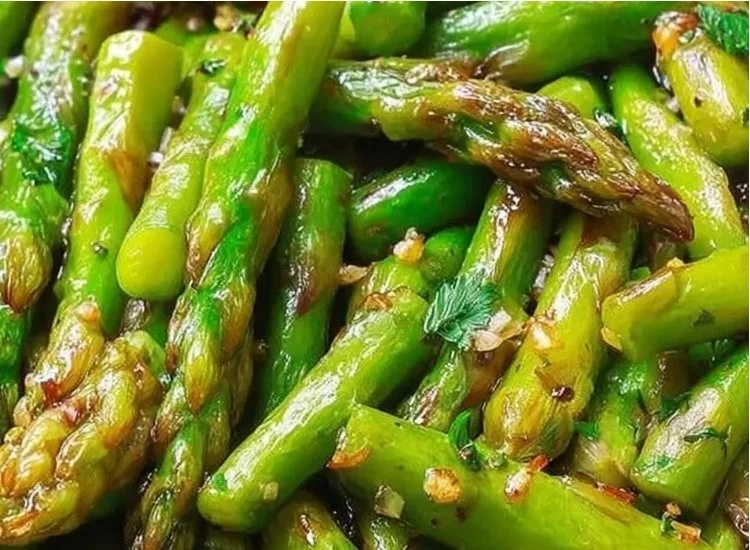 Crisp-tender asparagus cooked with lemon and garlic on a plate.